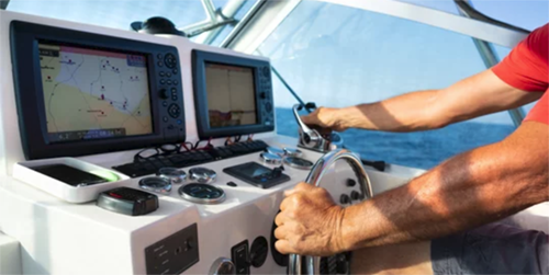 Man driving boat with GPS and Depth displays controlled by electronics