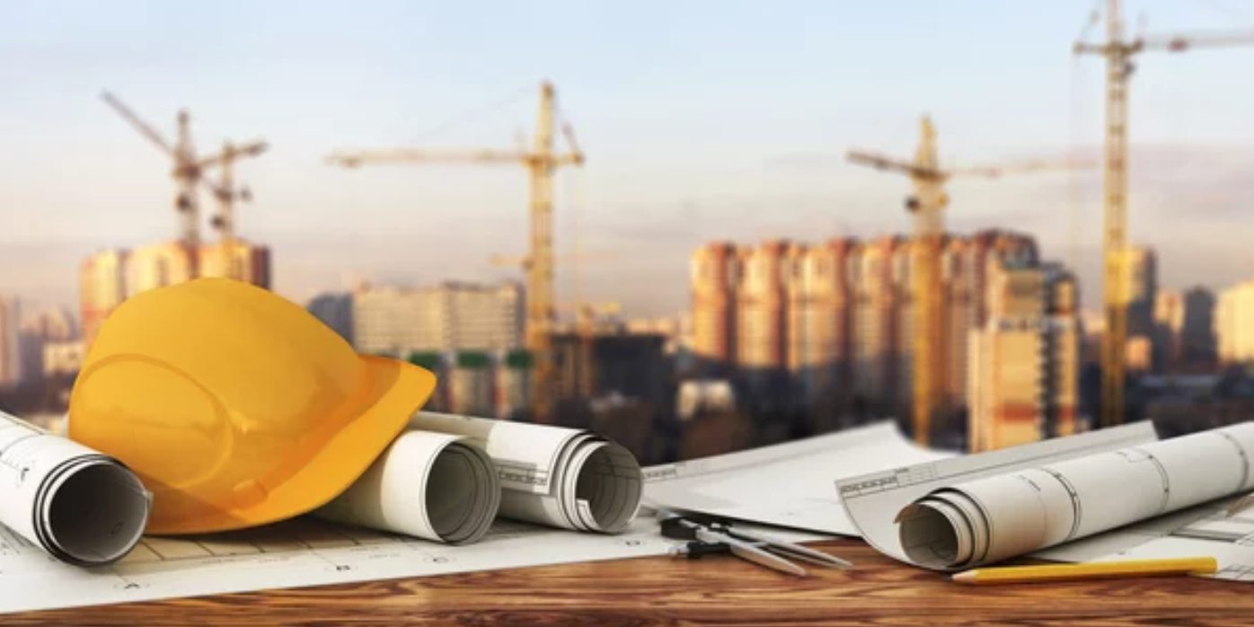 Hard hats and blueprints at construction site