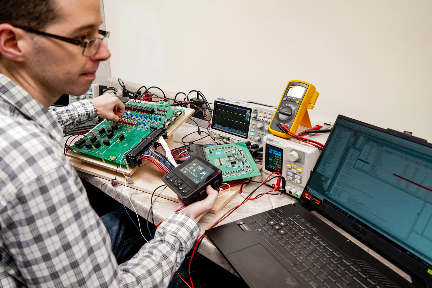 Engineer in front of computer testing components